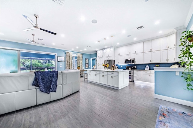 kitchen with appliances with stainless steel finishes, light hardwood / wood-style floors, an island with sink, ceiling fan, and white cabinets