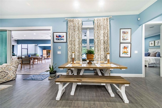 dining space with ornamental molding and dark hardwood / wood-style flooring