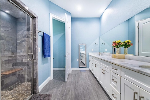 bathroom with vanity, an enclosed shower, and hardwood / wood-style flooring