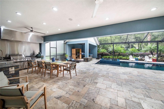 view of patio / terrace with a lanai, a grill, exterior kitchen, sink, and ceiling fan