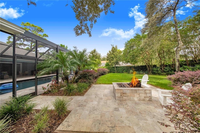 view of patio with a lanai and a fire pit