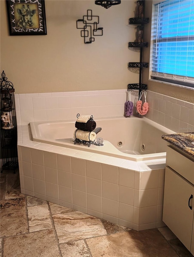 bathroom with vanity and tiled tub