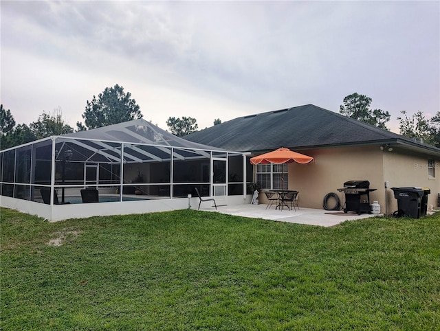 rear view of property featuring a lanai, a yard, and a patio