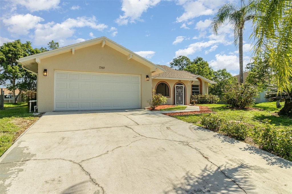 view of front of home with stucco siding, an attached garage, and concrete driveway
