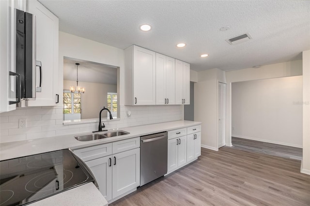 kitchen with dishwasher, light hardwood / wood-style floors, sink, a chandelier, and white cabinetry