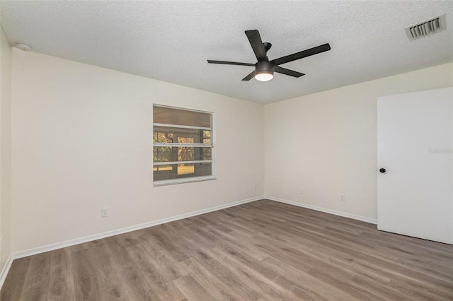 empty room with a textured ceiling, hardwood / wood-style floors, and ceiling fan