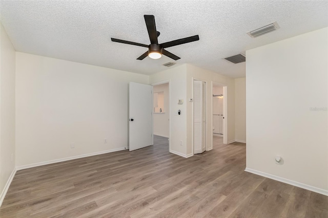 interior space featuring a textured ceiling, ceiling fan, and light wood-type flooring