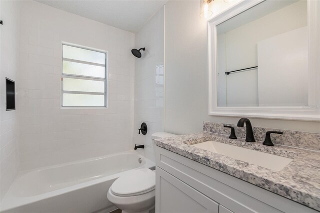 full bathroom featuring toilet, tiled shower / bath combo, and vanity