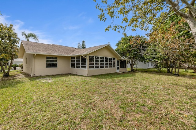 rear view of house with a yard and a sunroom