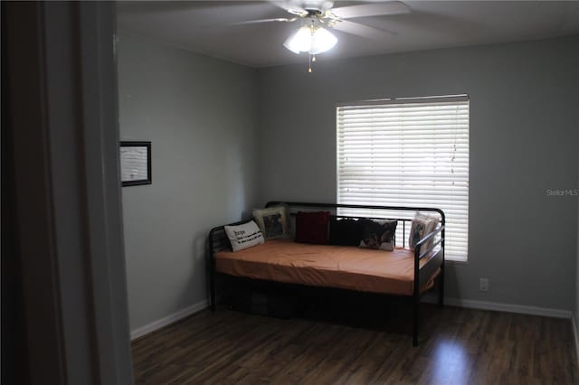 bedroom with dark wood-style floors, ceiling fan, and baseboards