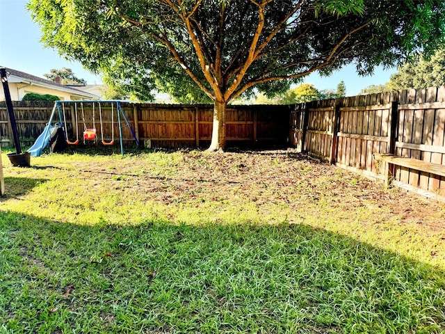 view of yard with a playground and a fenced backyard