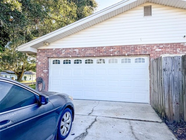 garage with driveway and fence