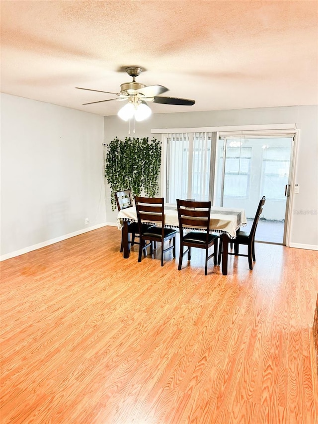 dining room with a textured ceiling, light wood-type flooring, and ceiling fan