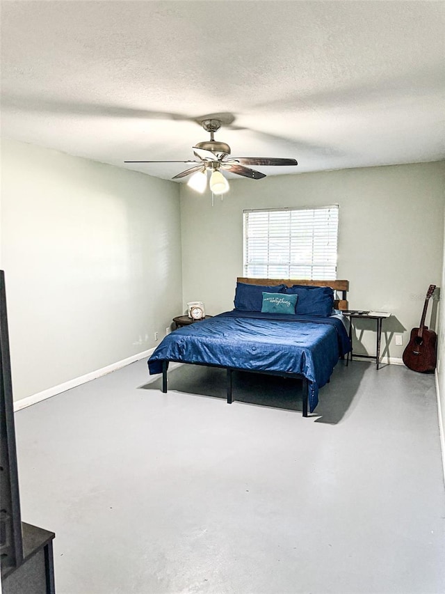 bedroom with ceiling fan, a textured ceiling, concrete floors, and baseboards