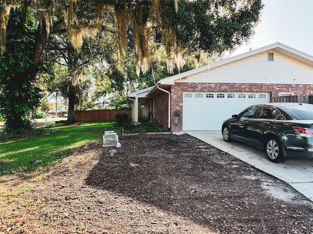 view of property exterior with a garage, brick siding, concrete driveway, and fence