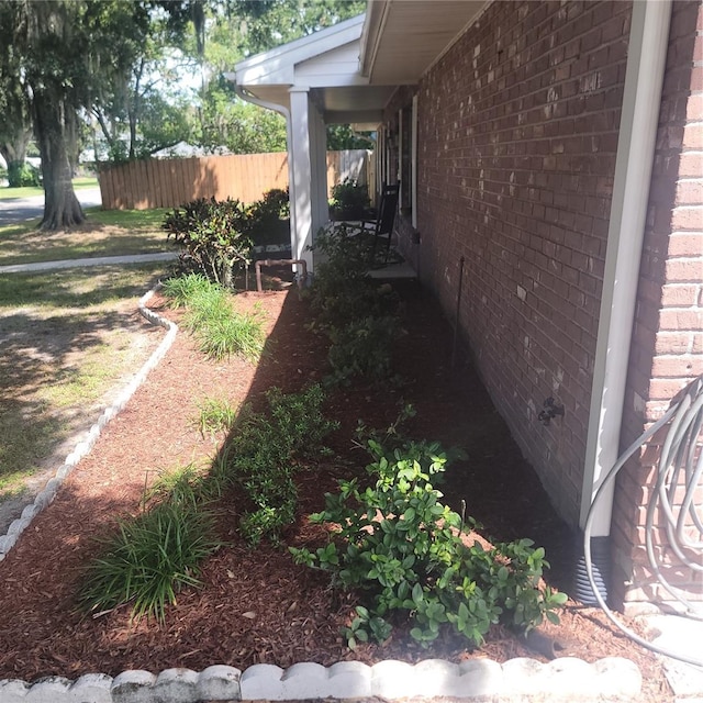 exterior space with brick siding and fence