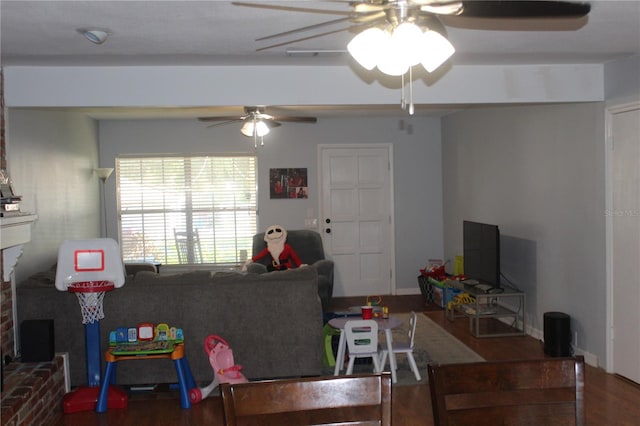 living area with baseboards, ceiling fan, and wood finished floors