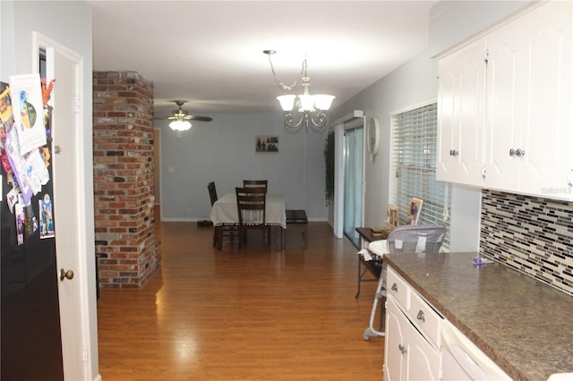 kitchen featuring white cabinetry, decorative backsplash, ceiling fan with notable chandelier, and light wood finished floors