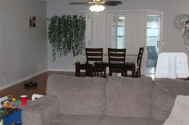 living area with baseboards, wood finished floors, and a ceiling fan