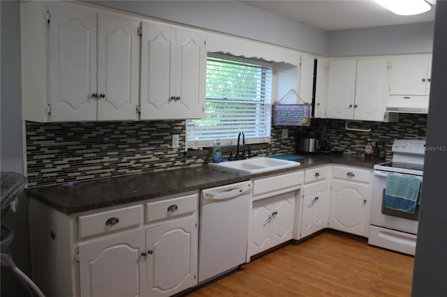 kitchen with white appliances, dark countertops, under cabinet range hood, and a sink