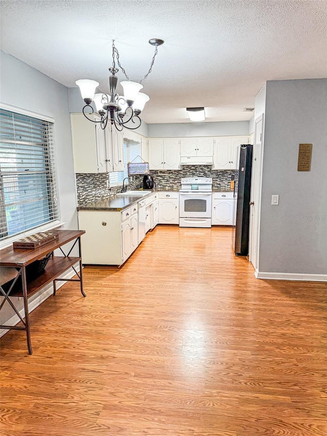 kitchen featuring a notable chandelier, light wood-style flooring, a sink, white appliances, and white cabinets