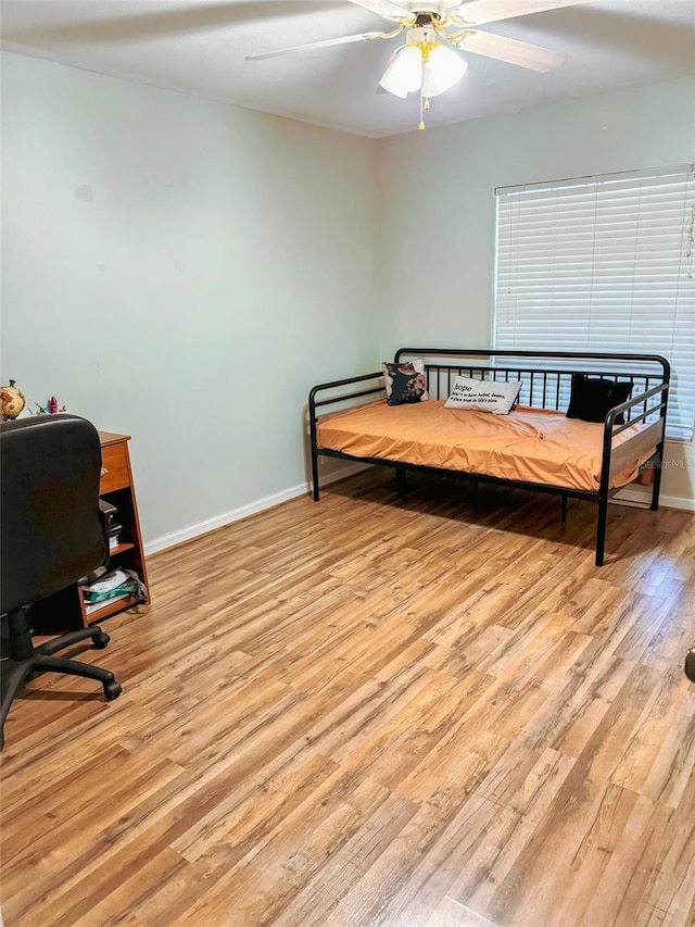 bedroom featuring ceiling fan, light wood-type flooring, and baseboards