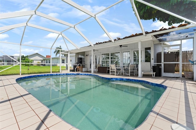 view of swimming pool with a lanai, a patio area, a lawn, ceiling fan, and french doors