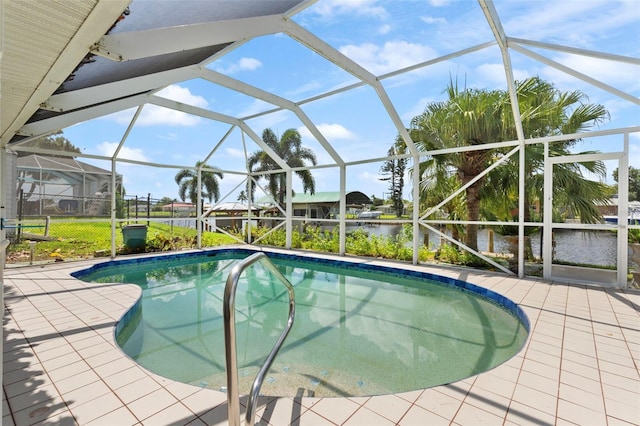 view of pool featuring glass enclosure, a water view, and a patio area