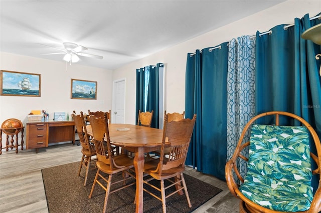 dining space with light wood-type flooring and ceiling fan