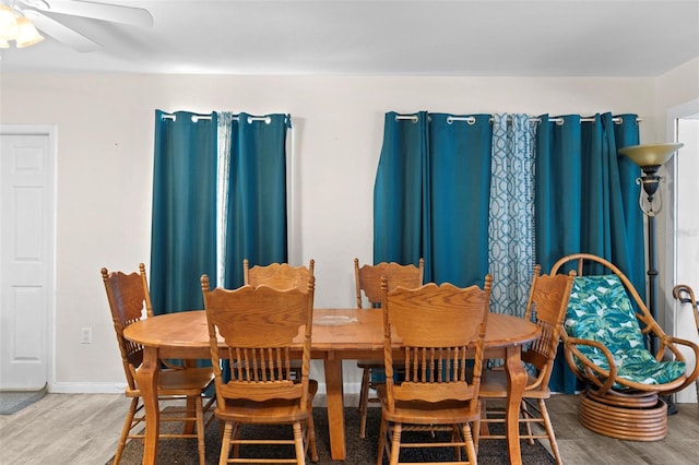 dining area featuring wood-type flooring and ceiling fan