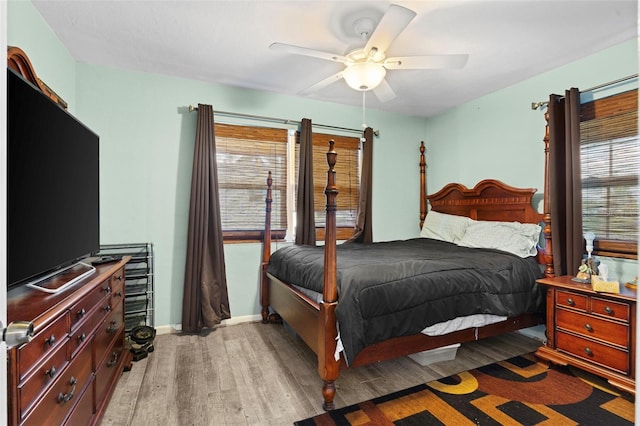 bedroom with multiple windows, ceiling fan, and wood-type flooring