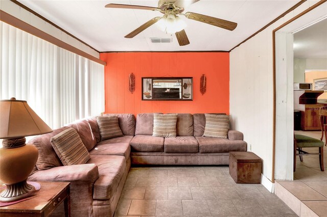 living room with ornamental molding and ceiling fan