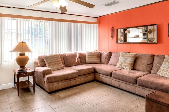 living room with ceiling fan, crown molding, and light tile patterned floors