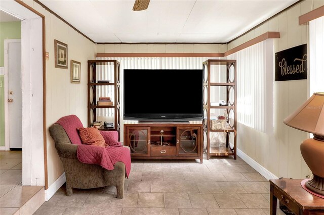 living room with ornamental molding and ceiling fan