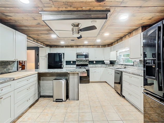 kitchen with appliances with stainless steel finishes, white cabinetry, ceiling fan, and light stone counters