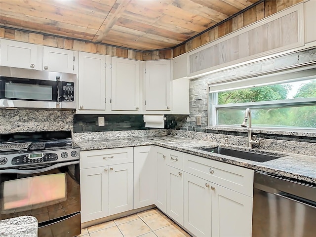 kitchen featuring white cabinets, light tile patterned flooring, sink, appliances with stainless steel finishes, and wooden ceiling