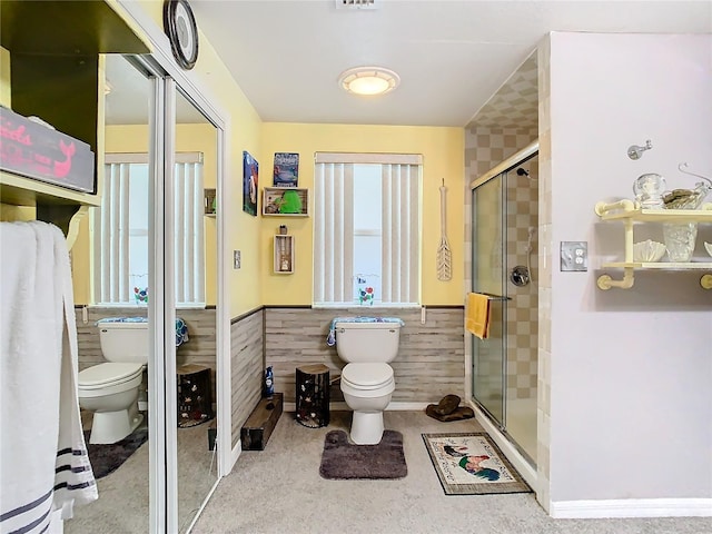 bathroom featuring wooden walls, toilet, and a shower with door