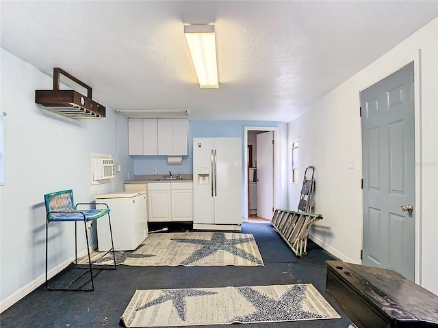 kitchen featuring white cabinetry, white refrigerator with ice dispenser, white refrigerator, a textured ceiling, and sink