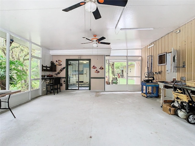 interior space featuring wooden walls and ceiling fan