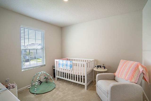 carpeted bedroom with a nursery area and a textured ceiling