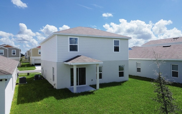 back of property with a yard and central AC unit