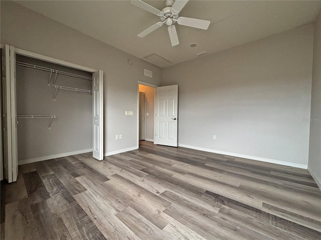 unfurnished bedroom with hardwood / wood-style flooring, ceiling fan, and a closet