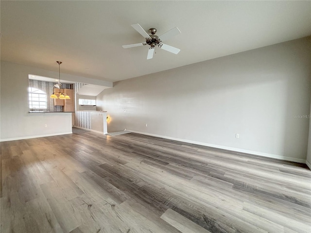 unfurnished living room featuring hardwood / wood-style floors and ceiling fan