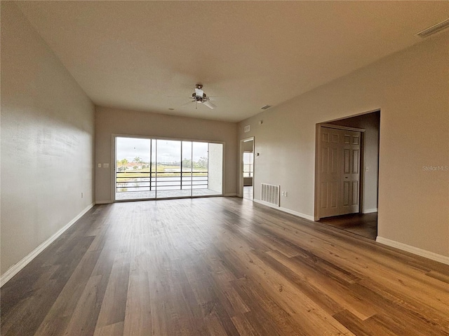 empty room featuring dark wood-type flooring and ceiling fan