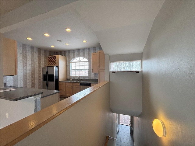 kitchen featuring appliances with stainless steel finishes, sink, light brown cabinetry, and kitchen peninsula