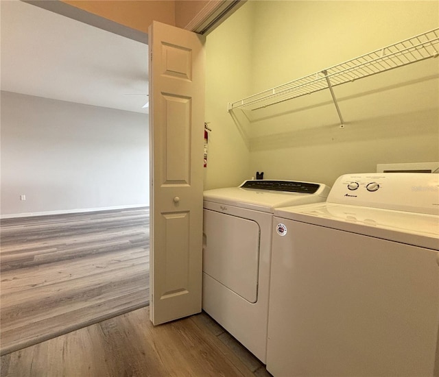 washroom with independent washer and dryer and light wood-type flooring