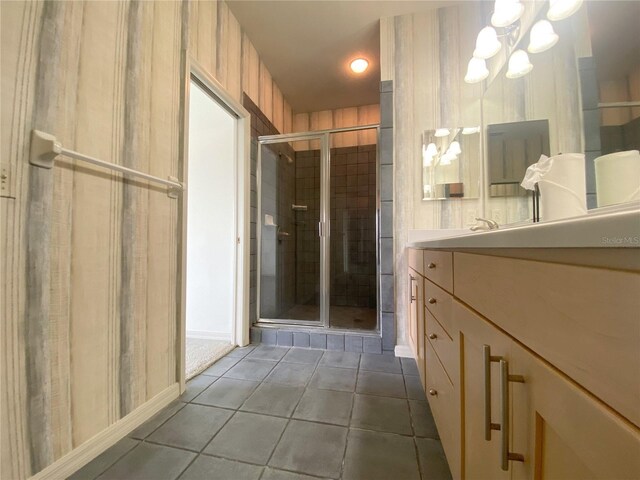 bathroom featuring a notable chandelier, vanity, tile patterned flooring, and a shower with shower door