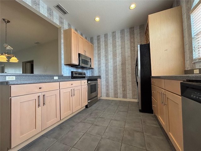 kitchen with kitchen peninsula, light brown cabinets, stainless steel appliances, and pendant lighting