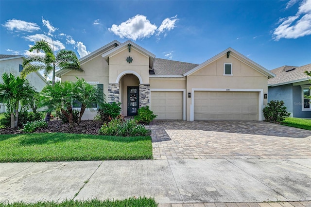 single story home with a garage and a front lawn