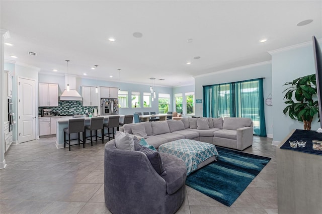 living room with ornamental molding and light tile patterned floors